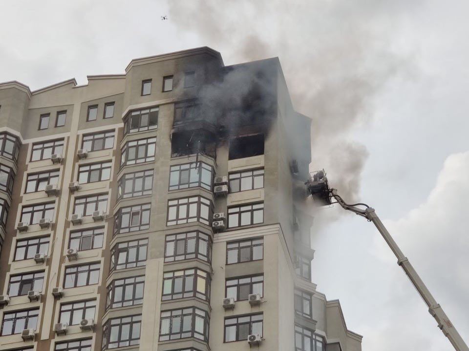Людина стоїть над прірвою, стовпи диму видно на кілометри: у Києві палає багатоповерхівка, є загиблий (фото, відео)